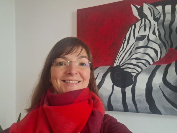 Lidija vor einem Zebrabild mit rotem Hintergrund