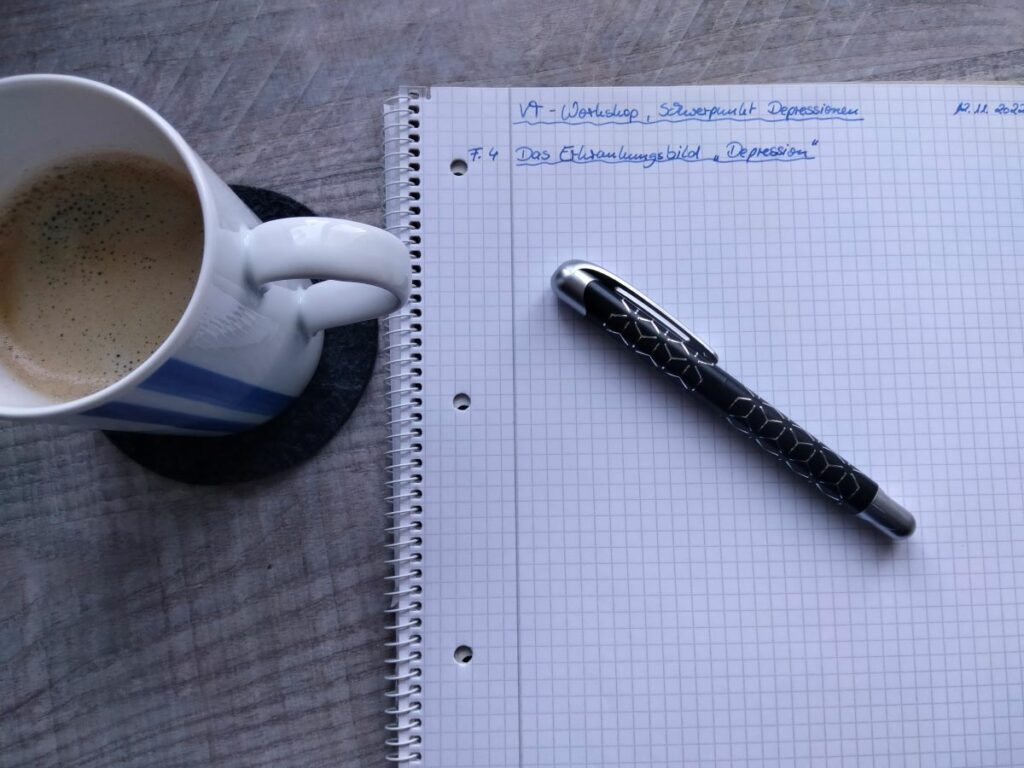 Kaffee, Schreibblock und Tintenroller